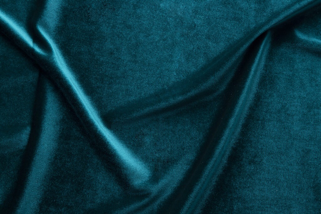 Close up of teal blue velvet upholstery fabric