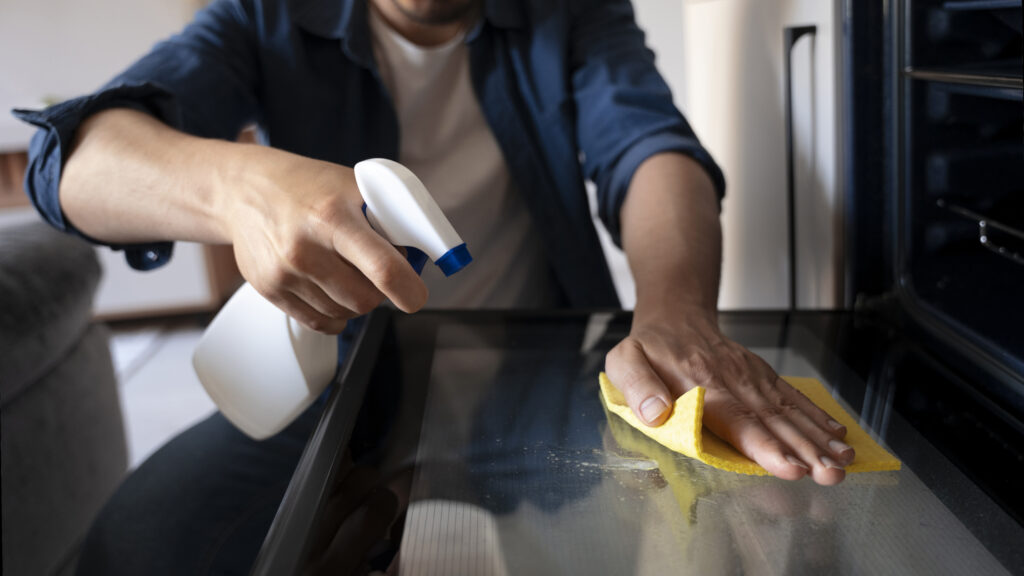 spraying and wiping a glass shiner on a glass table