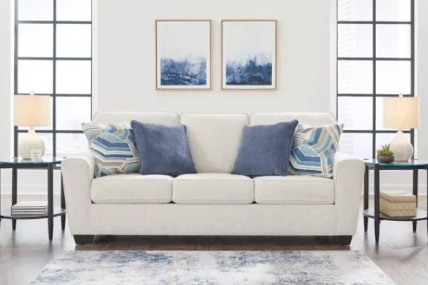 Light and airy spring home decor with light-colored sofas, bright accents, glass end tables, minimalist table lamps, and wall art